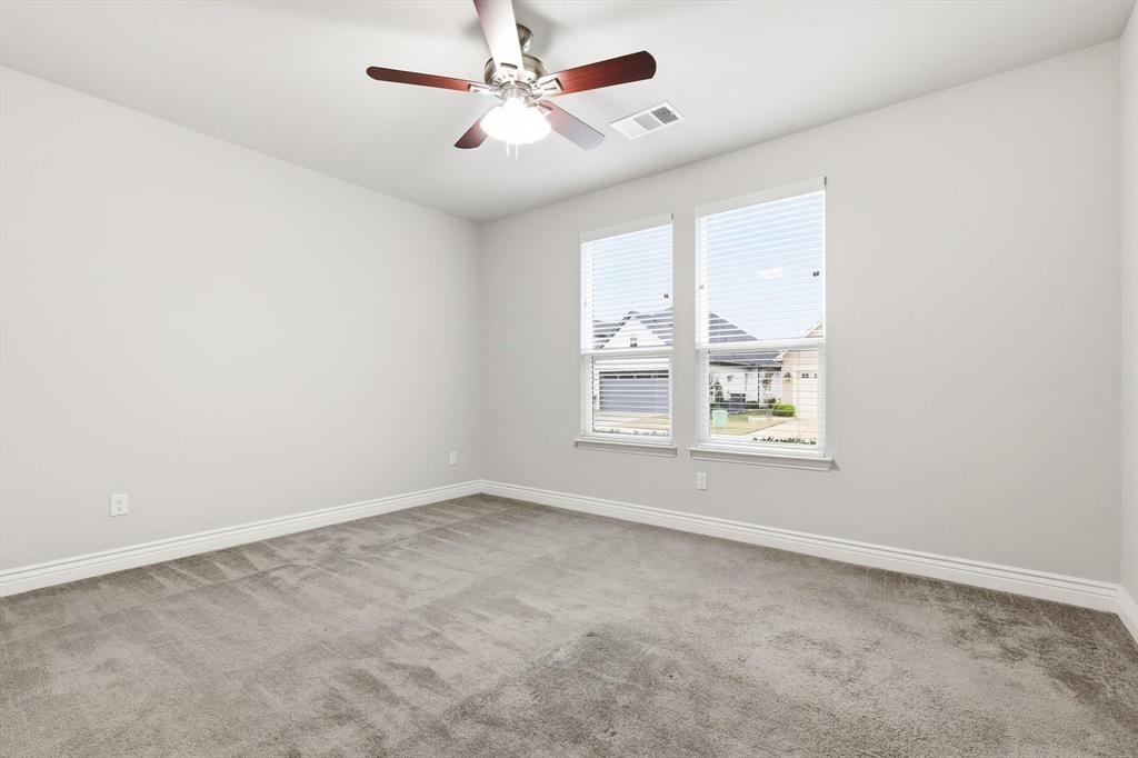 8813 Basanite Avenue Denton, TX 76207 - Photo 26 of 40 an empty room with windows and ceiling fan