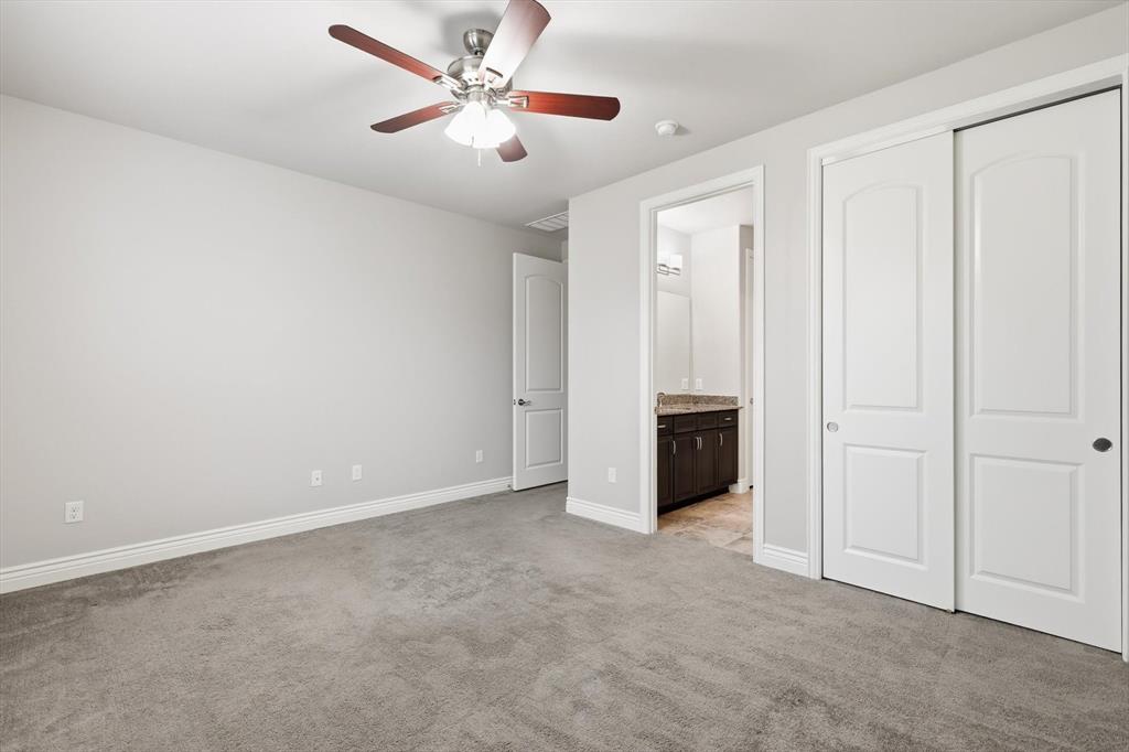 8813 Basanite Avenue Denton, TX 76207 - Photo 27 of 40 an empty room with a ceiling fan and carpet