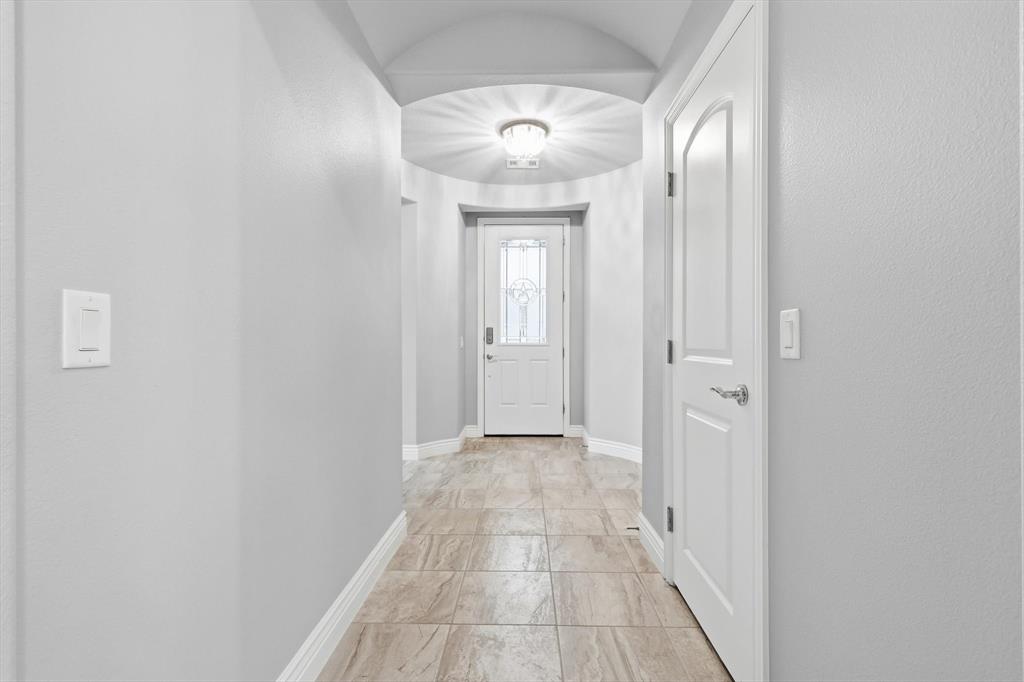 8813 Basanite Avenue Denton, TX 76207 - Photo 40 of 40 a view of a hallway with wooden floor and a mirror