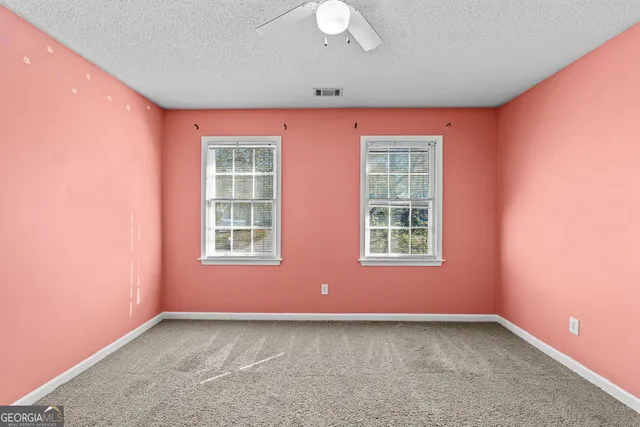 an empty room with a ceiling fan and a window