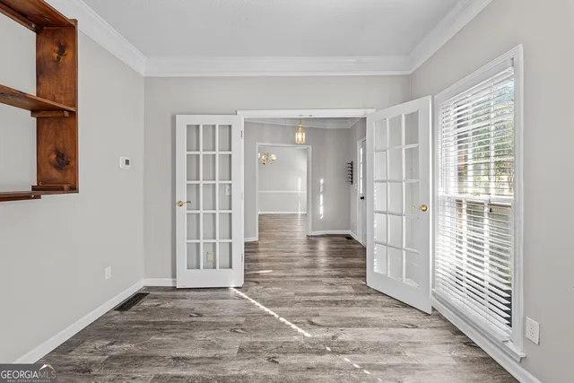 a view of a hallway with wooden floor and a bathroom