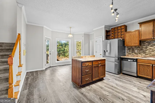 a large kitchen with stainless steel appliances granite countertop a stove a sink dishwasher and a refrigerator