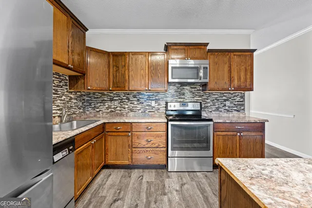 a kitchen with a stove sink and cabinets