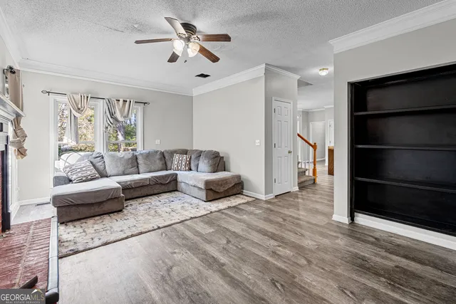 a living room with furniture ceiling fan and a window