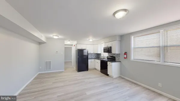 a view of a kitchen with a sink a refrigerator and window