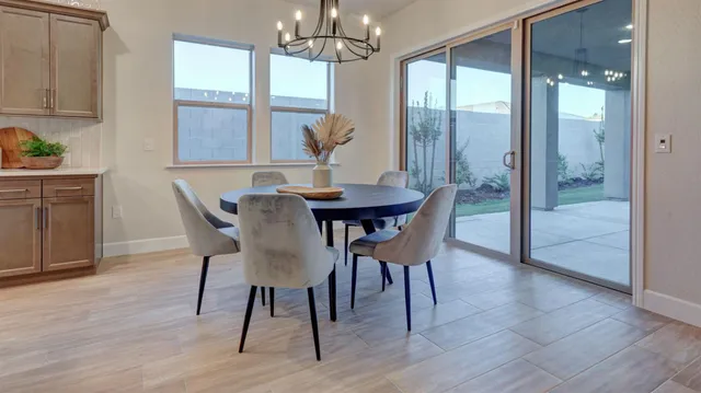 a view of a dining room with furniture a chandelier and wooden floor
