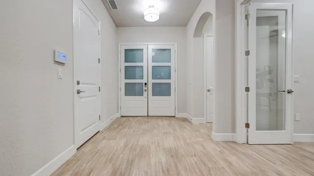 an empty room with wooden floor and windows