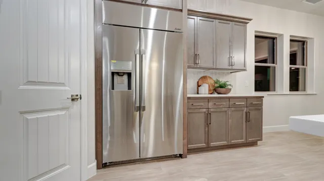 a kitchen with stainless steel appliances granite countertop a refrigerator and a sink