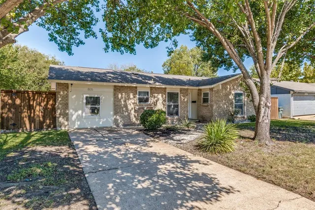 a view of a house with a tree in the yard