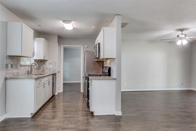 a kitchen with stainless steel appliances granite countertop a stove a sink and a refrigerator