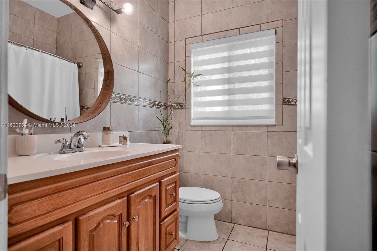 6411 Southwest 41st Street Miami, FL 33155 - Photo 8 of 17 a bathroom with a granite countertop sink toilet a mirror and shower