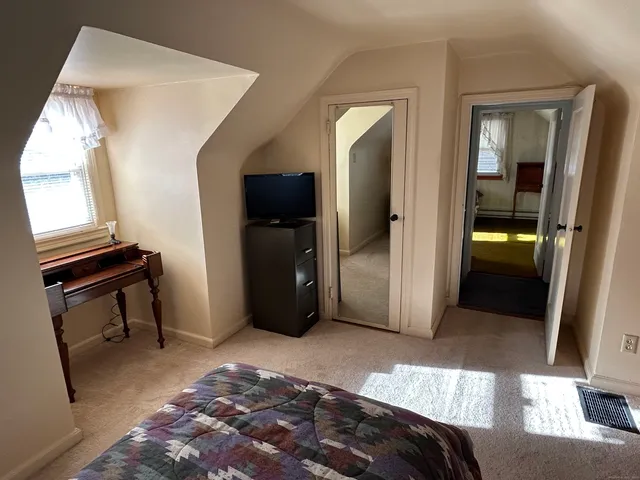 a bedroom with a bed and a mirror