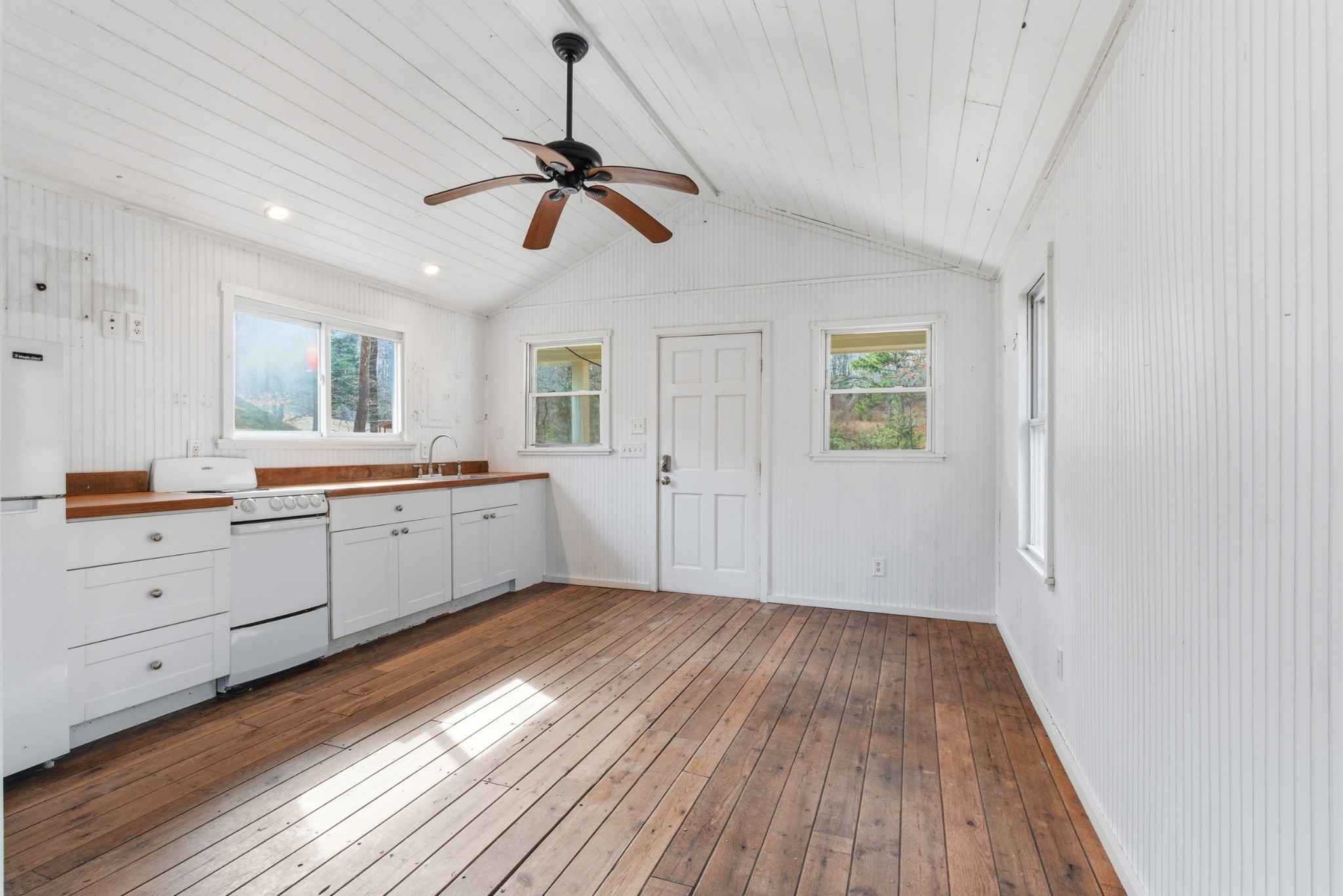 3972 Skelley Road Santa Fe, TN 38482 - Photo 24 of 47 a view of a kitchen with wooden floor a ceiling fan and windows