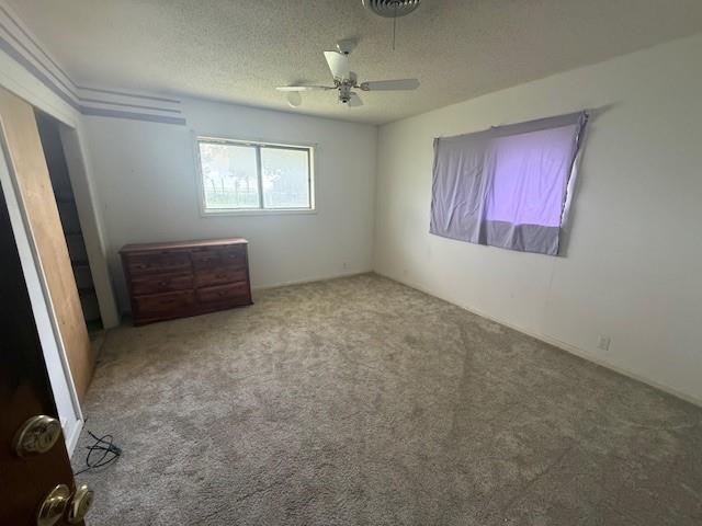 909 Railroad Street Rochester, TX 79544 - Photo 12 of 19 Unfurnished bedroom with carpet flooring, a textured ceiling, and a ceiling fan