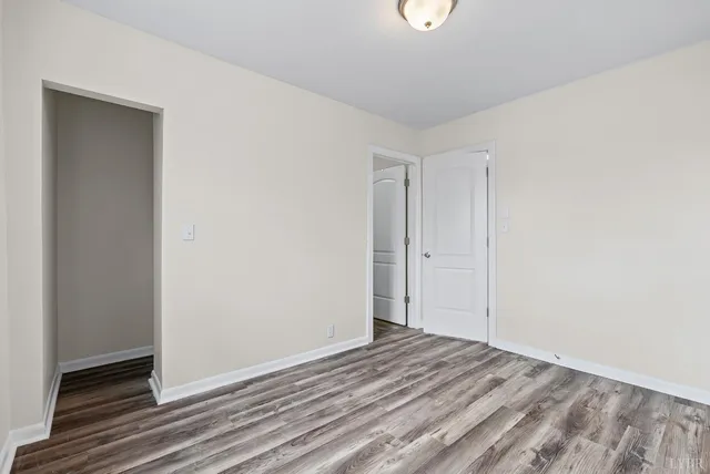a view of a room with wooden floor