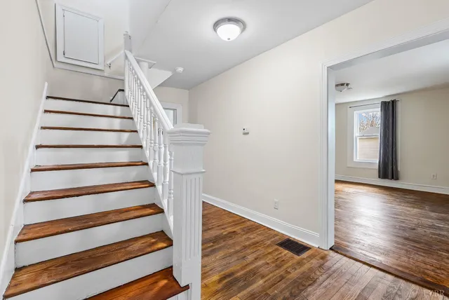 a view of entryway with wooden floor and stairs