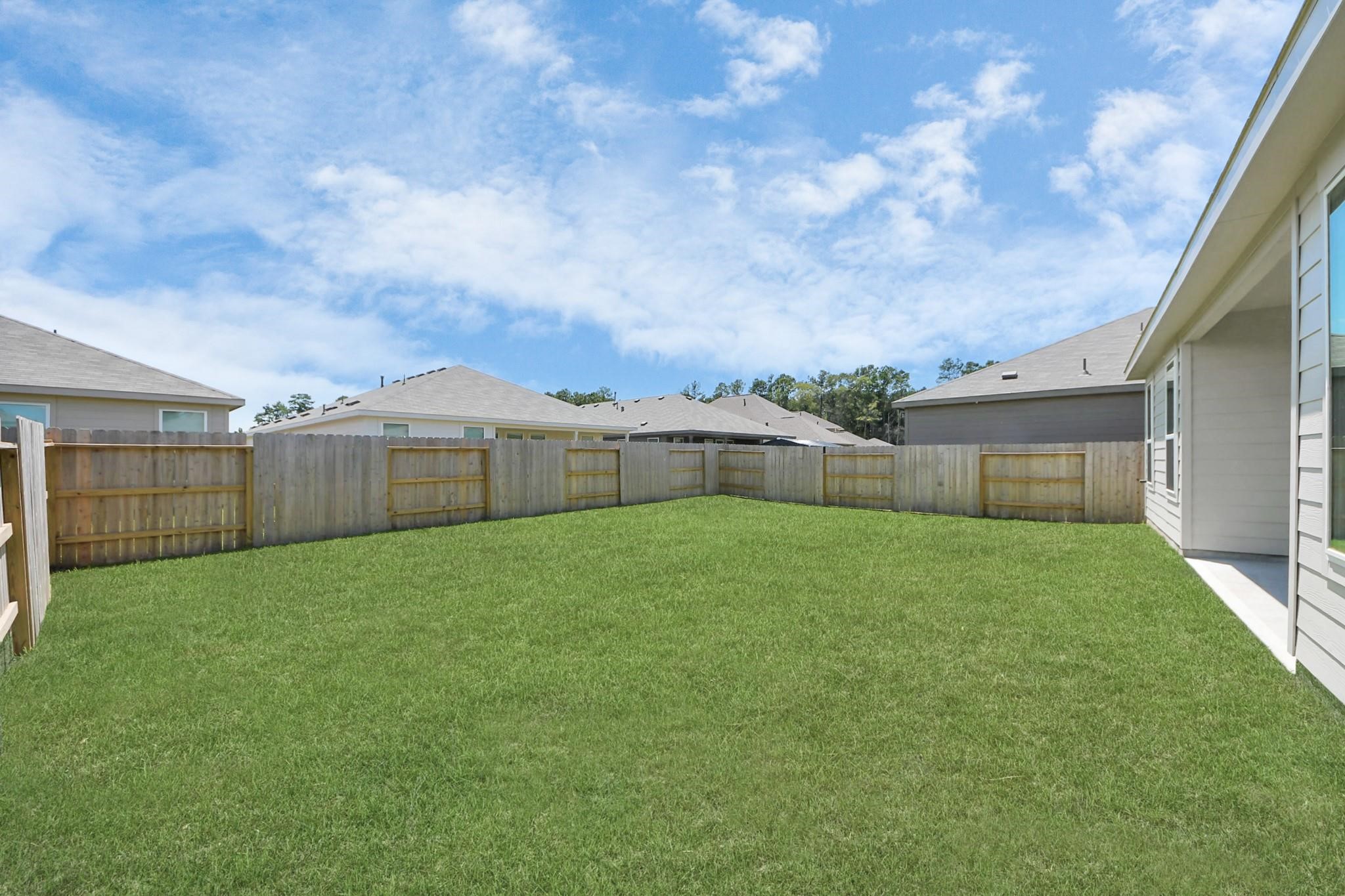 10650 Ellerston Road Cleveland, TX 77327 - Photo 22 of 25 Spacious backyard is fully fenced, offering a safe and private outdoor retreat