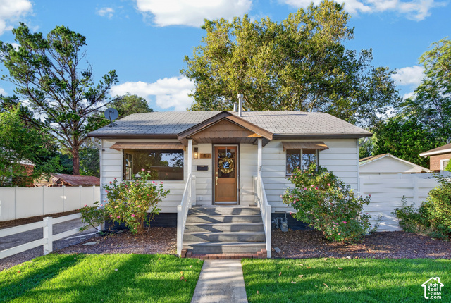 147 Center Street Clearfield, UT 84015 - Photo 54 of 55 Exterior featuring white siding, a covered entry, a gabled roofline, and a paved walkway