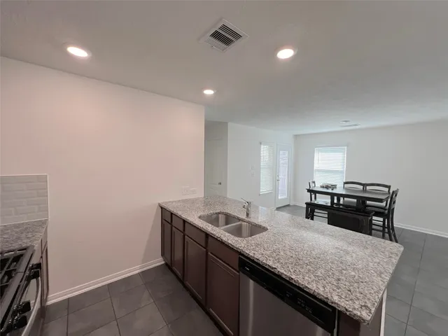a kitchen with granite countertop sink stove and cabinets