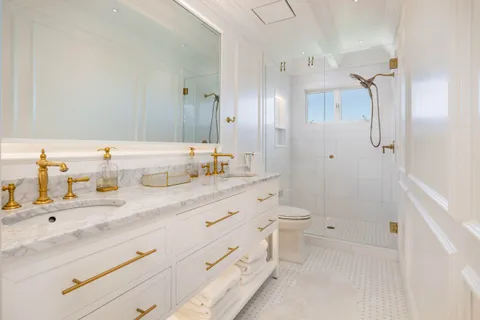 a bathroom with a granite countertop sink a toilet and shower