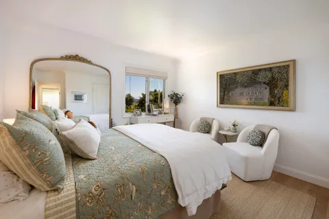 a bedroom with bed and a painting on the wall