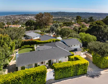 an aerial view of multiple houses with a swimming pool