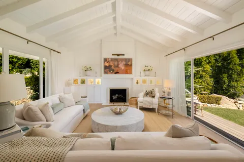 a living room with furniture large window and a fireplace