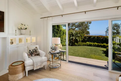 a living room with patio furniture and a yard