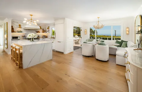 a open kitchen with white cabinets and stainless steel appliances
