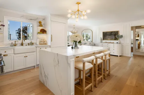 a kitchen with stainless steel appliances a sink stove and wooden floor