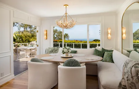 a dining room with furniture a large window and a chandelier