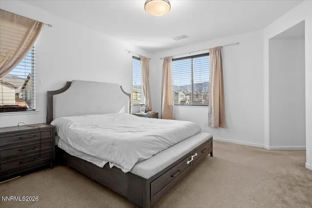 a bed sitting in a bedroom next to a window