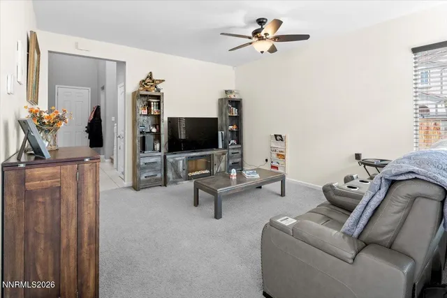 a living room with furniture a flat screen tv and a window