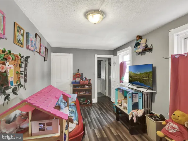 a living room with furniture a flat screen tv and a dining table with wooden floor