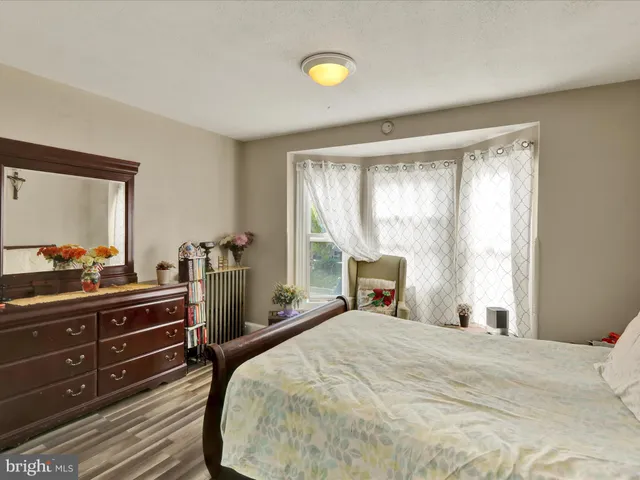 a bedroom with a bed and a dresser with mirror