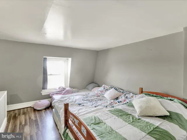 a bedroom with a bed and a wooden floor