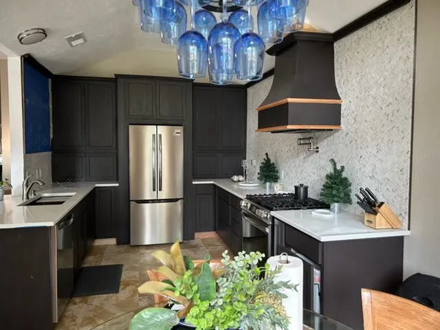 a kitchen with stainless steel appliances granite countertop a sink a stove and a refrigerator