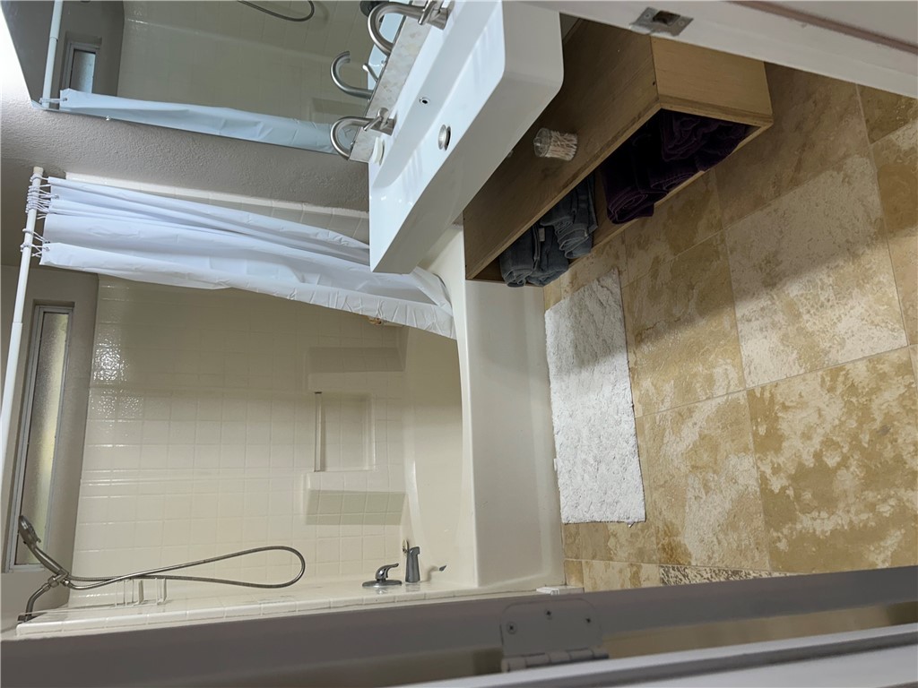 2230 Howell Avenue Bryan, TX 77803 - Photo 11 of 14 a bathroom with a double vanity sink a mirror and a bathtub