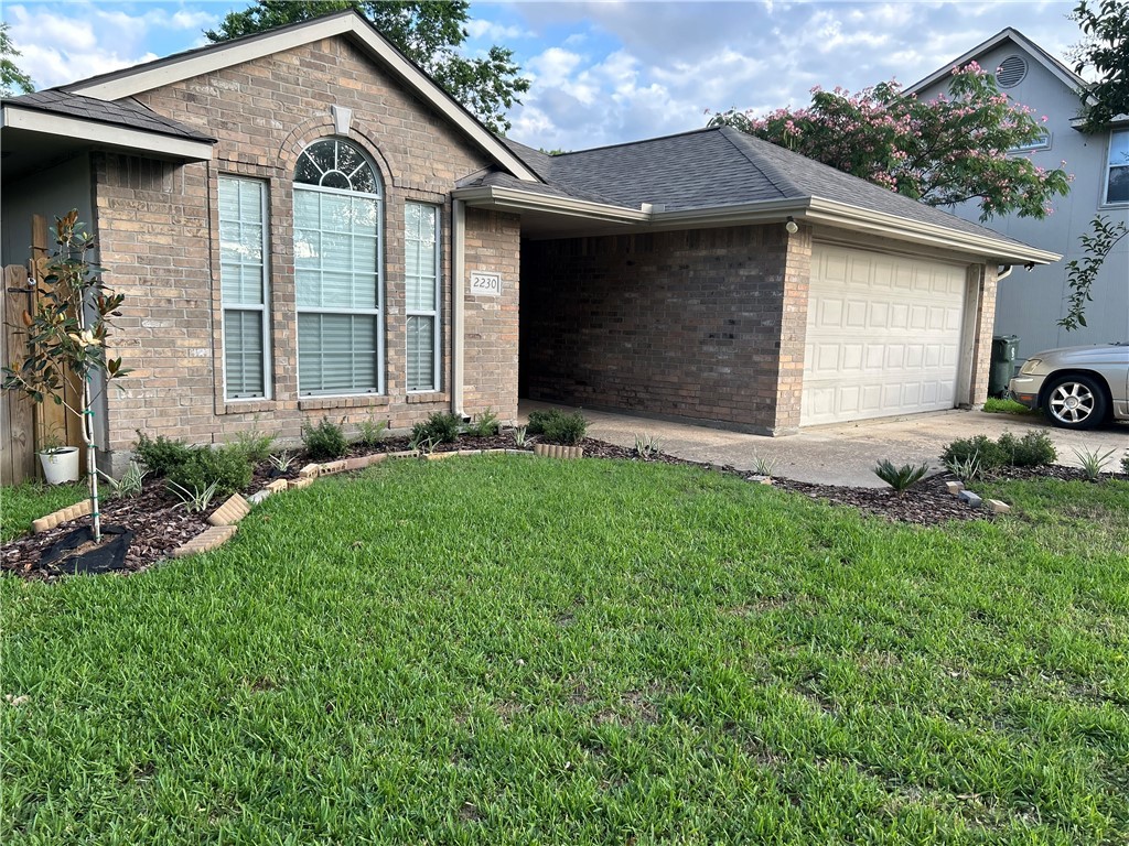 2230 Howell Avenue Bryan, TX 77803 - Photo 3 of 14 a front view of a house with a yard and garage