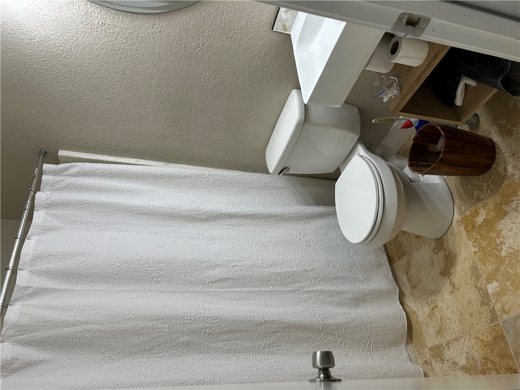 2230 Howell Avenue Bryan, TX 77803 - Photo 9 of 14 a bathroom with a toilet and a shower curtain