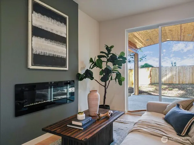 a living room with furniture a fireplace and a potted plant