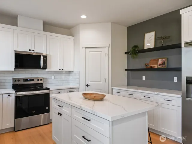 a kitchen with stainless steel appliances a stove microwave and sink