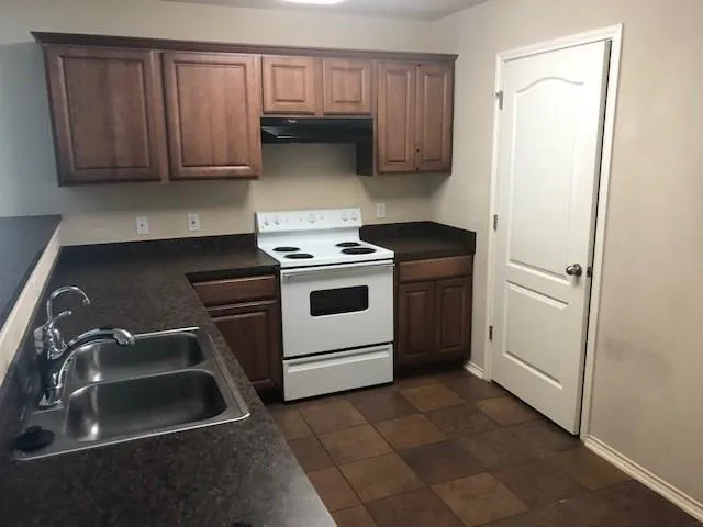 a kitchen with a stove sink and cabinets