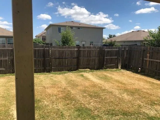 a view of small yard with wooden fence