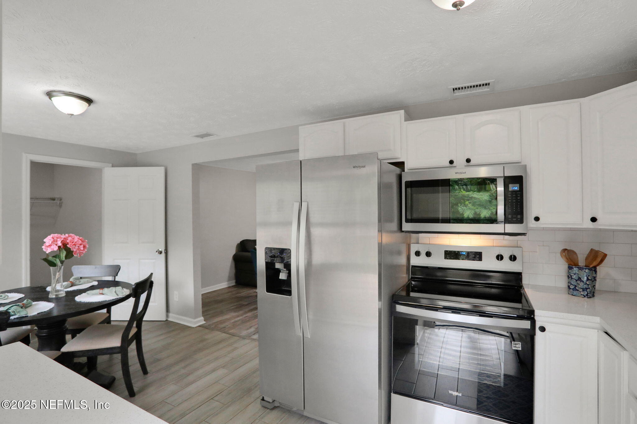 3822 Packard Drive Jacksonville, FL 32246 - Photo 12 of 38 a kitchen with stainless steel appliances a stove a refrigerator a sink a dining table and chairs with wooden floor