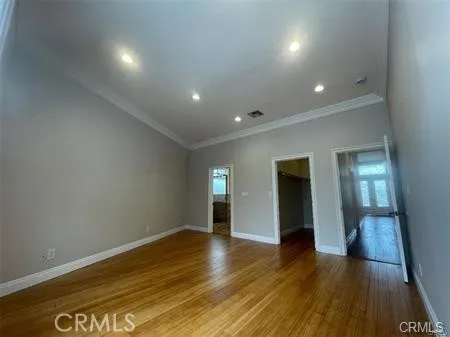 an empty room with wooden floor and mirror