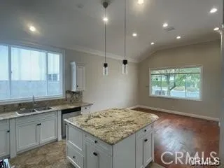 a kitchen with granite countertop sink stove and cabinets