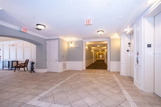 a view of a hallway with furniture and a chandelier