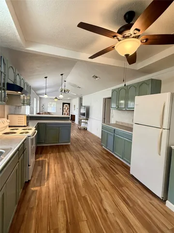 a kitchen with kitchen island wooden floors stainless steel appliances and sink
