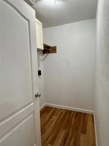 a view of a room with wooden floor and white walls
